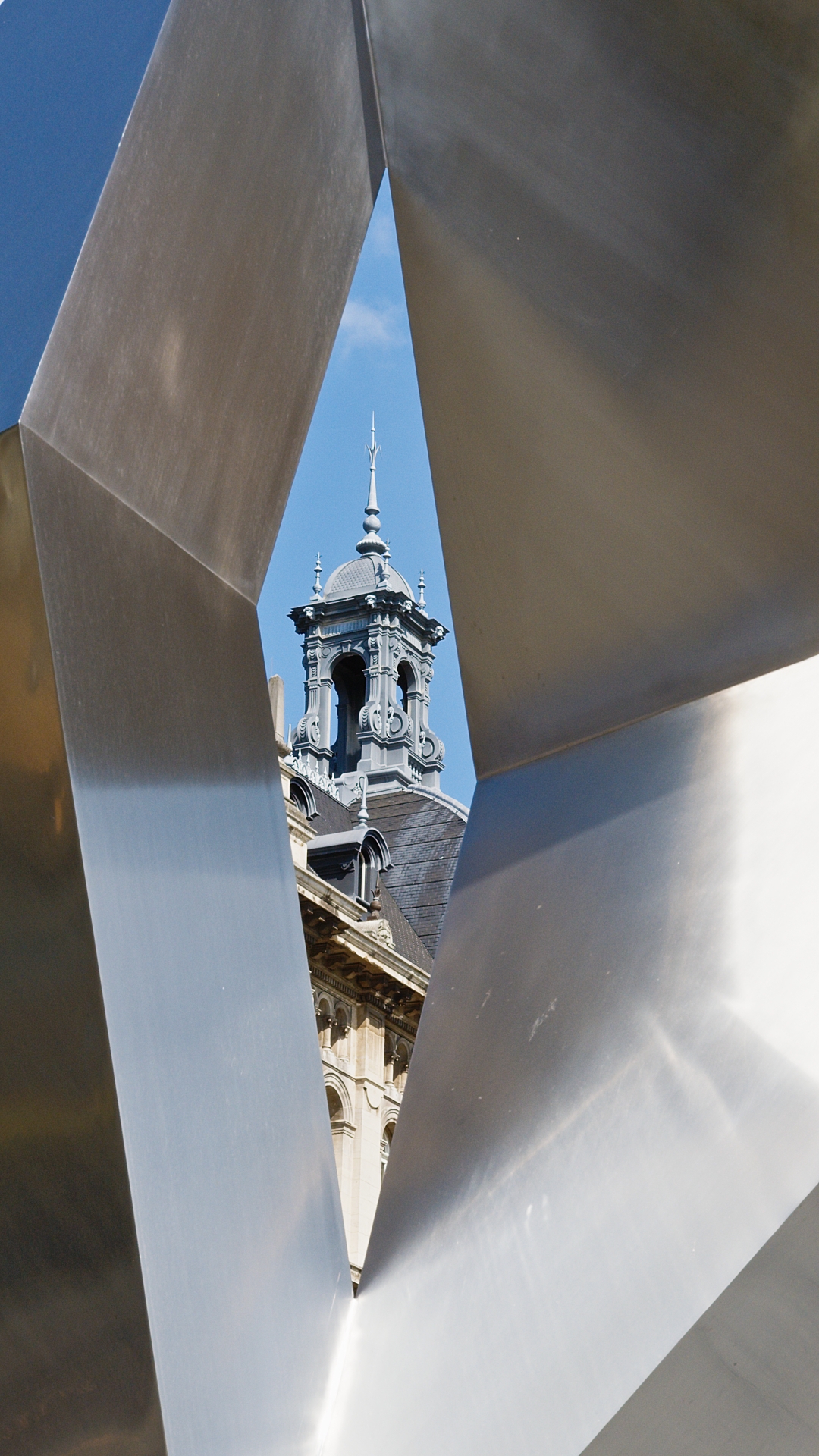 La arquitectura de Amberes vista a través del marco de una escultura metálica moderna